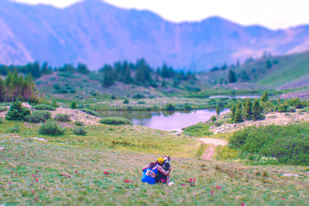 Kate sits among the Indian Paintbrushes with Moose to soak up the mountain view.