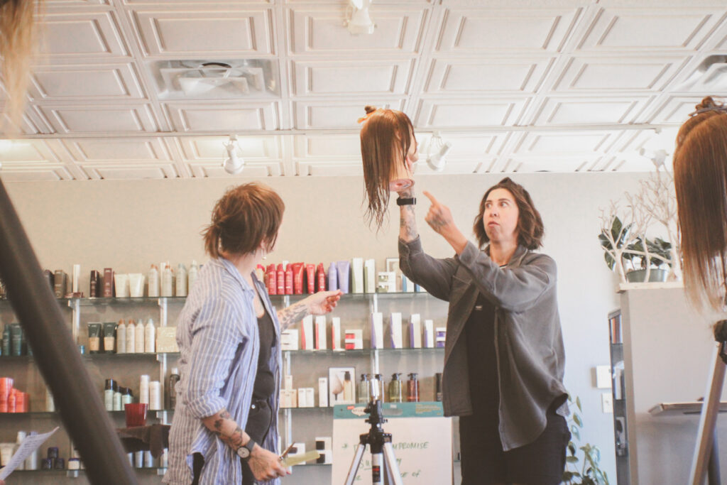 Amber and Hallie lead the texture cutting class by demonstrating on a mannequin head.